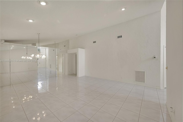 unfurnished room featuring light tile patterned floors and a chandelier