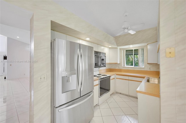 kitchen with appliances with stainless steel finishes, light tile patterned floors, white cabinetry, and ceiling fan