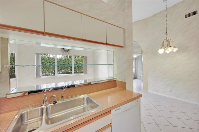 kitchen featuring pendant lighting, white cabinets, sink, dishwasher, and an inviting chandelier