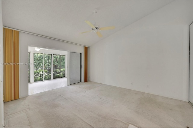 spare room featuring ceiling fan, light carpet, and vaulted ceiling