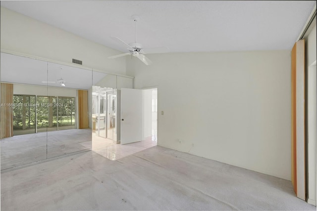 unfurnished room with ceiling fan, light colored carpet, and vaulted ceiling