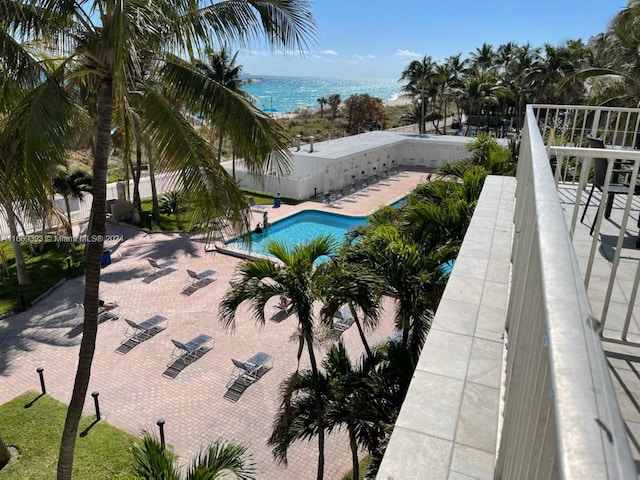 view of pool with a water view and a patio area