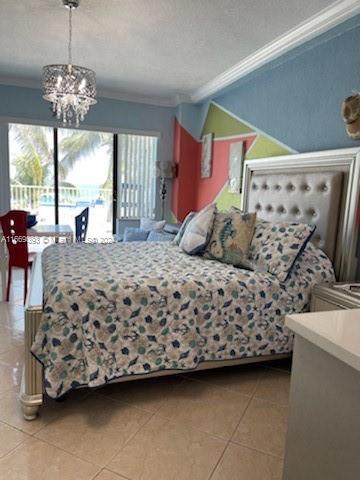 tiled bedroom with a textured ceiling, access to outside, ornamental molding, and an inviting chandelier