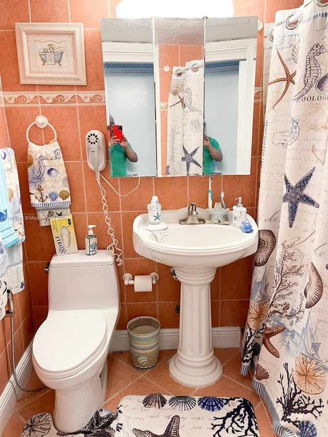 bathroom featuring tile walls, tile patterned flooring, curtained shower, and toilet