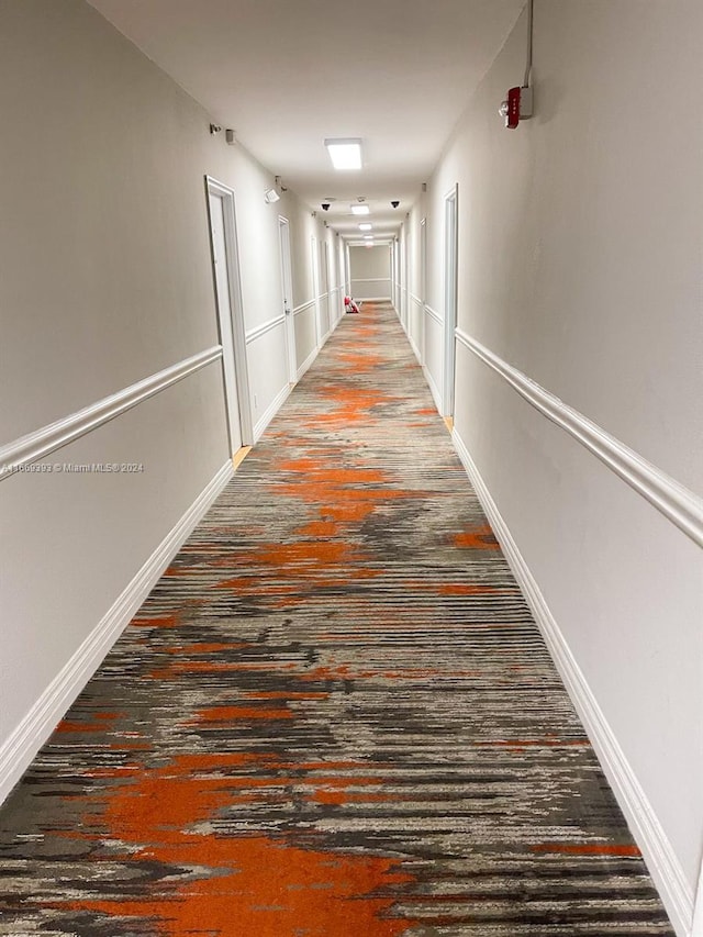 hallway featuring wood finished floors and baseboards