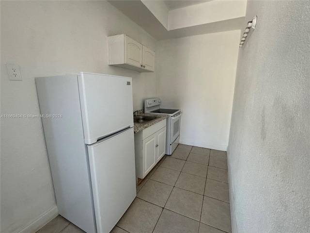 kitchen featuring white appliances, white cabinetry, and light tile patterned floors