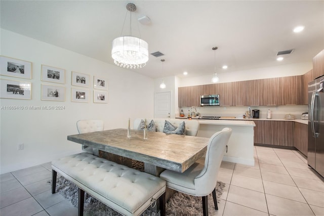 dining room featuring light tile patterned floors, sink, and a chandelier