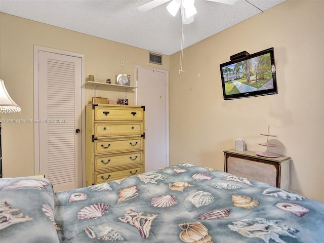 bedroom featuring a textured ceiling, ceiling fan, and a closet