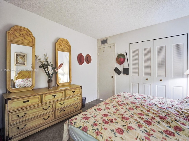 bedroom with a textured ceiling, a closet, and dark colored carpet