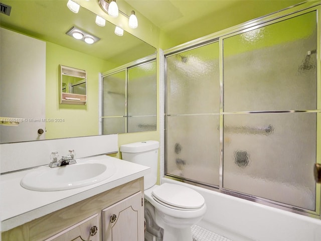 full bathroom with shower / bath combination with glass door, vanity, toilet, and tile patterned floors