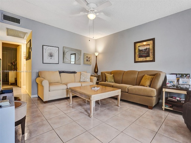 tiled living room with ceiling fan and a textured ceiling