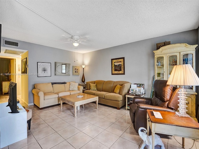 living room featuring ceiling fan, a textured ceiling, and light tile patterned floors