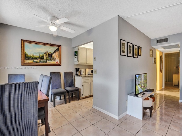 dining room with ceiling fan, light tile patterned floors, and a textured ceiling