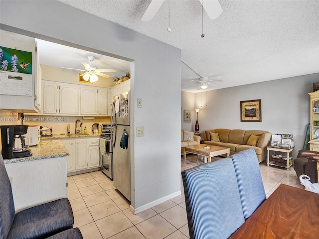 kitchen featuring appliances with stainless steel finishes, a textured ceiling, sink, and ceiling fan