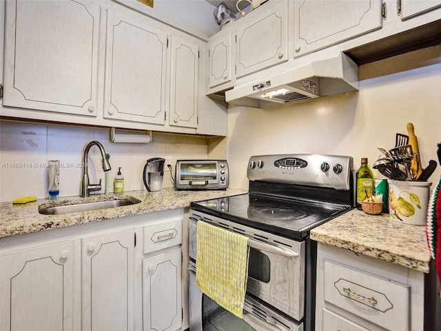 kitchen with tasteful backsplash, sink, electric stove, white cabinetry, and light stone countertops