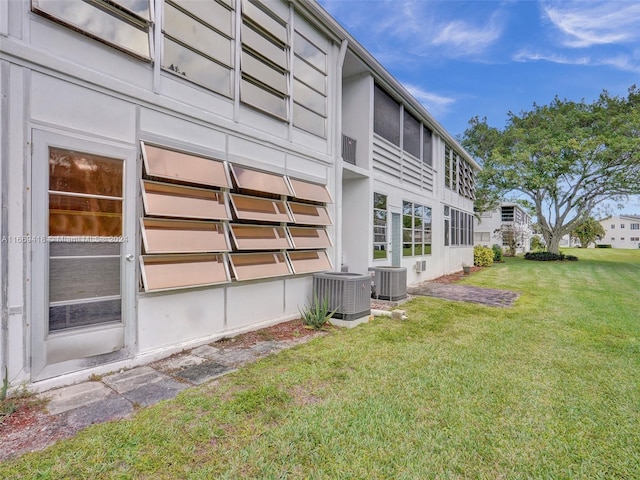 view of side of home with cooling unit and a yard