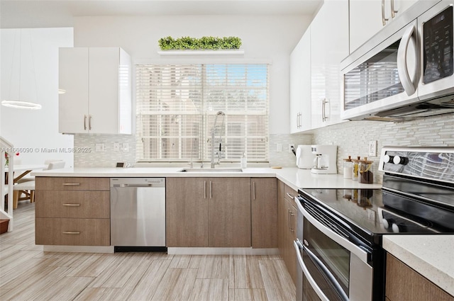 622 SW 147th Ter, Pembroke Pines, FL 33027 - kitchen with appliances with stainless steel finishes, decorative backsplash, light countertops, a sink, and white cabinets