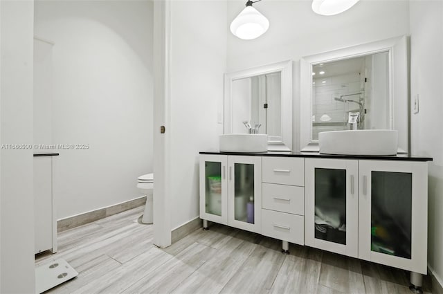 bathroom with an enclosed shower, vanity, toilet, and hardwood / wood-style floors