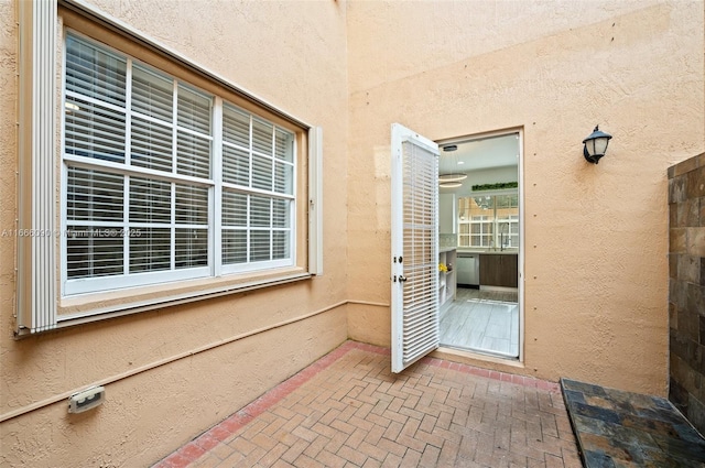 view of exterior entry with a patio