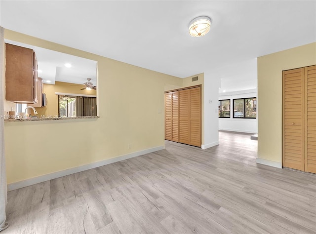 unfurnished living room with light hardwood / wood-style flooring and ceiling fan