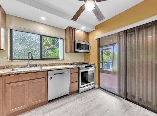 kitchen with appliances with stainless steel finishes, ceiling fan, and sink