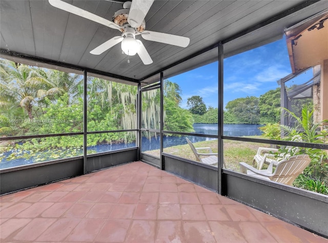 unfurnished sunroom featuring ceiling fan, a water view, and wood ceiling