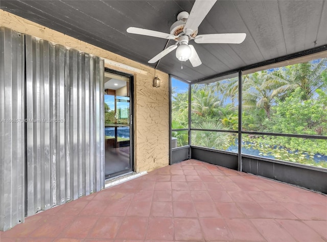 unfurnished sunroom with ceiling fan