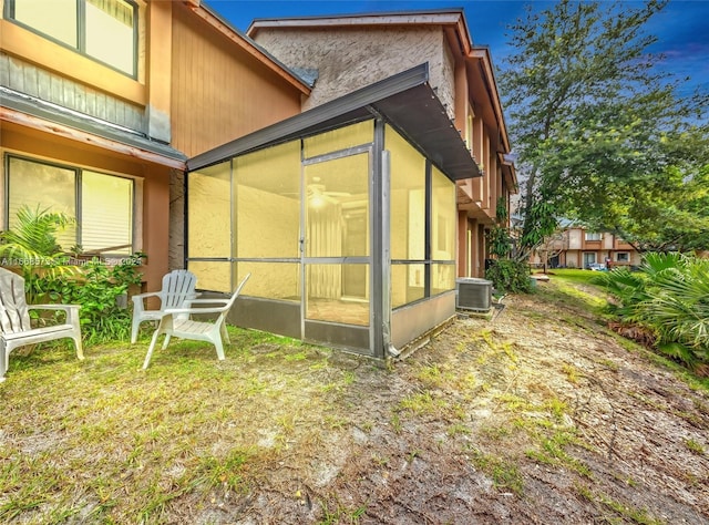 view of side of property featuring a sunroom and cooling unit