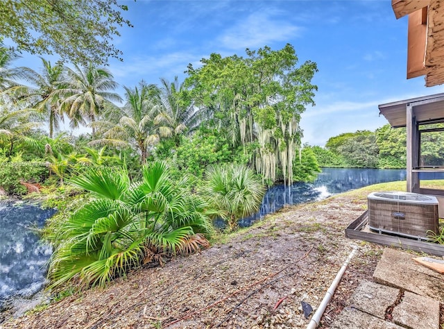 view of yard with cooling unit and a water view