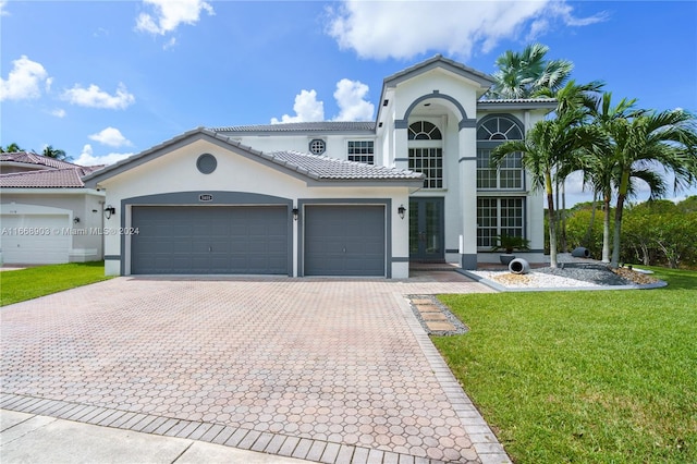 mediterranean / spanish home with a garage and a front yard