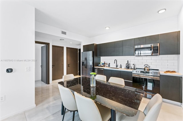 398 NE 5th St Unit 1419, Miami, FL 33132 - kitchen featuring stainless steel appliances, tasteful backsplash, modern cabinets, dark cabinets, and recessed lighting