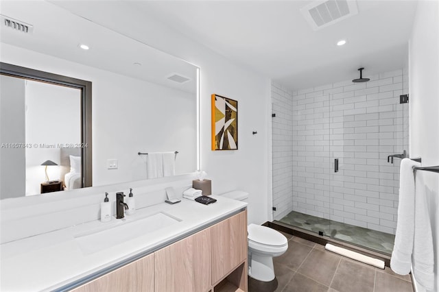 bathroom with vanity, a shower with shower door, toilet, and tile patterned floors