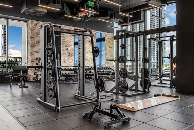 398 NE 5th St Unit 1419, Miami, FL 33132 - exercise room with a wall of windows, healthy amount of natural light, a high ceiling, and brick wall