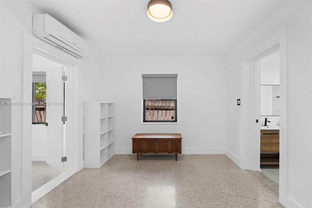 corridor featuring a wall unit AC and sink