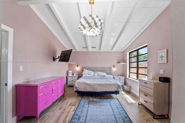 bedroom featuring a chandelier, light hardwood / wood-style floors, and lofted ceiling with beams