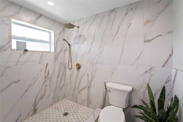 bathroom featuring tile walls, toilet, and tiled shower