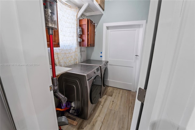 laundry room featuring cabinets, light hardwood / wood-style flooring, and washing machine and dryer