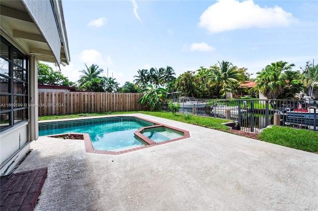 view of pool featuring a patio and an in ground hot tub