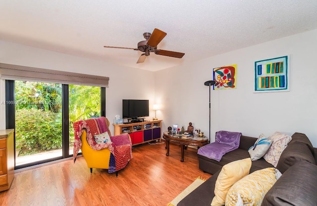 living room with a textured ceiling, hardwood / wood-style flooring, and ceiling fan