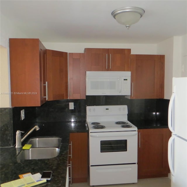 kitchen with dark stone countertops, sink, white appliances, and decorative backsplash