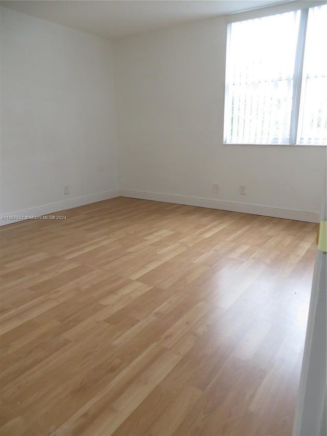 unfurnished room featuring light wood-style floors and baseboards
