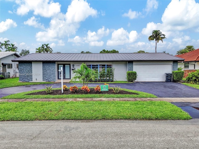 single story home featuring a garage and a front yard