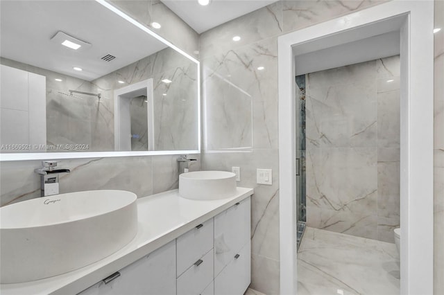 bathroom featuring vanity, tile walls, a tile shower, and toilet