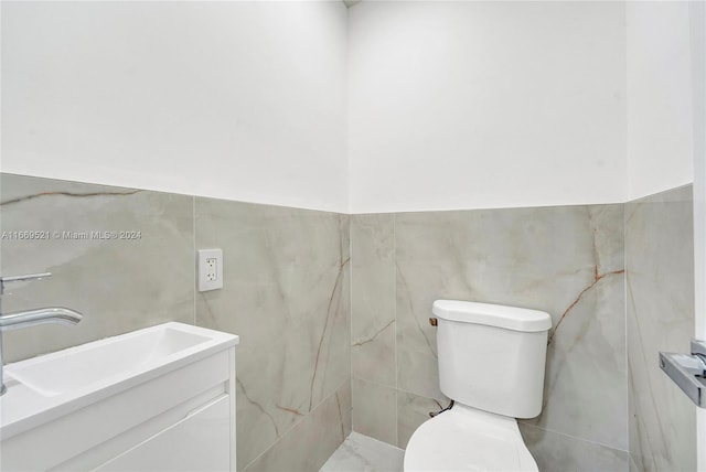 bathroom featuring tile walls, vanity, and toilet