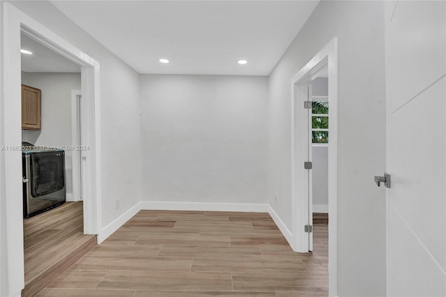 corridor featuring light wood-type flooring and washer / clothes dryer