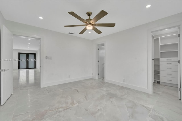 unfurnished bedroom featuring ceiling fan, a closet, and a walk in closet