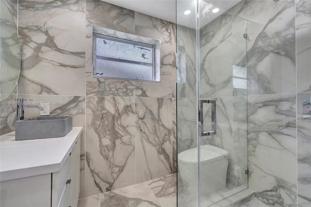 bathroom with tile walls, vanity, toilet, and a shower with door