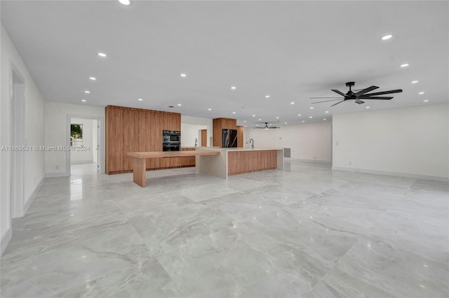 unfurnished living room with sink and ceiling fan