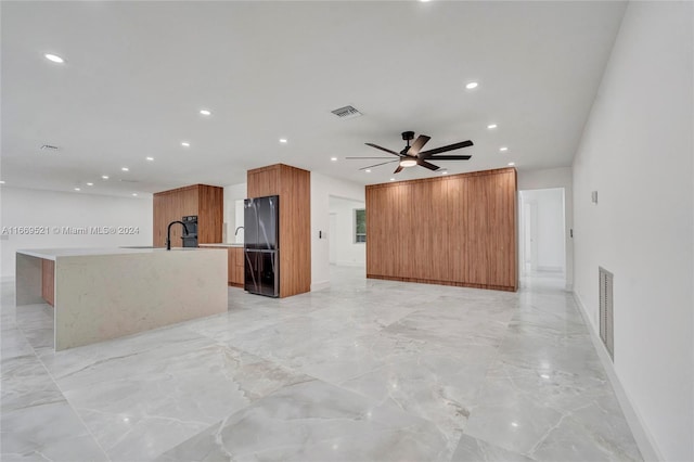 unfurnished living room with ceiling fan and sink