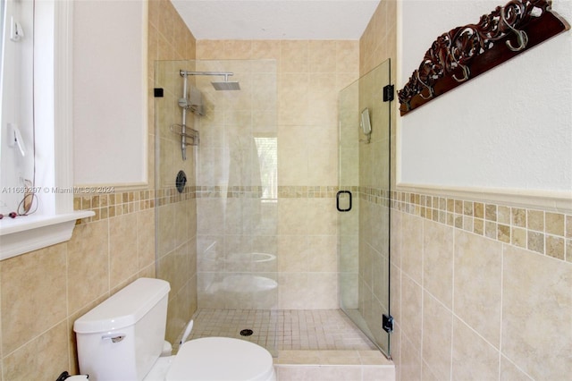 bathroom featuring tile walls, walk in shower, and toilet